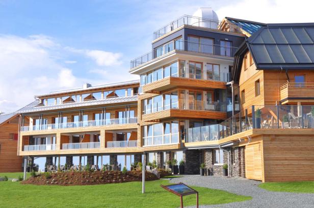 Ein modernes Hotel mit Holzelementen und einer Kuppel auf dem Dach.