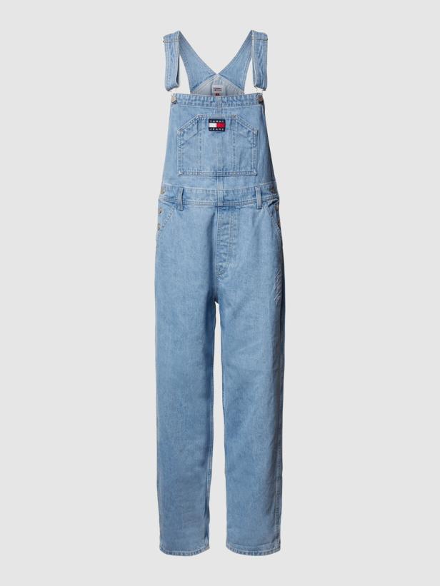 Eine hellblaue Jeans-Latzhose von Tommy Jeans vor einem neutralen Hintergrund.