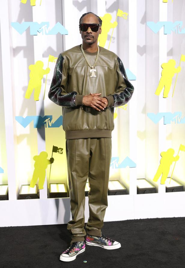 Snoop Dogg posiert auf dem schwarzen Teppich vor einem MTV-Hintergrund.