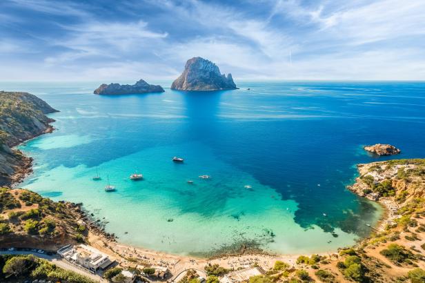 Blick auf die Küste von Ibiza mit türkisfarbenem Wasser und der Felseninsel Es Vedrà.