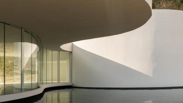 Der Oscar Niemeyer Pavillon mit seiner geschwungenen Architektur und dem reflektierenden Wasserbecken.