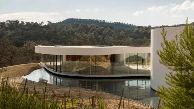 Der Oscar Niemeyer Pavillon, ein modernes Gebäude mit Glasfassade, umgeben von einem Wasserbecken.