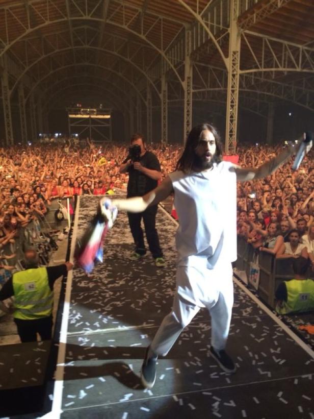 Jared Leto tritt vor einer großen Menschenmenge auf einer Bühne auf.