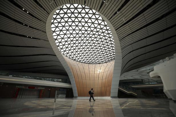 Eine Person geht durch die leere Halle des Flughafens Peking-Daxing.