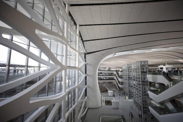 Das Innere eines modernen Flughafens mit markanter Architektur und vielen Ebenen.