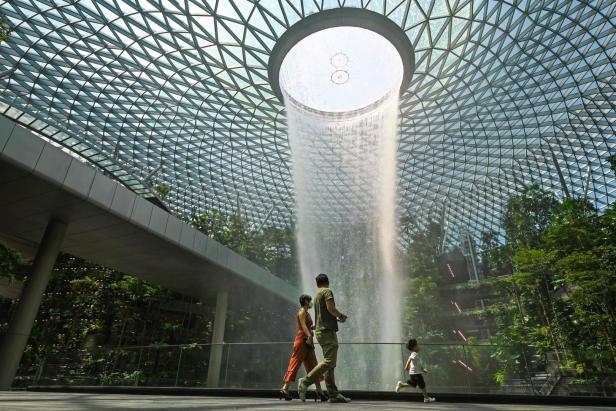 Eine Familie besucht den Wasserfall im Jewel Changi Airport in Singapur.