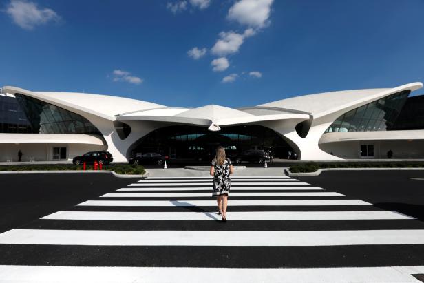 Eine Frau überquert einen Zebrastreifen vor dem TWA Hotel in New York.