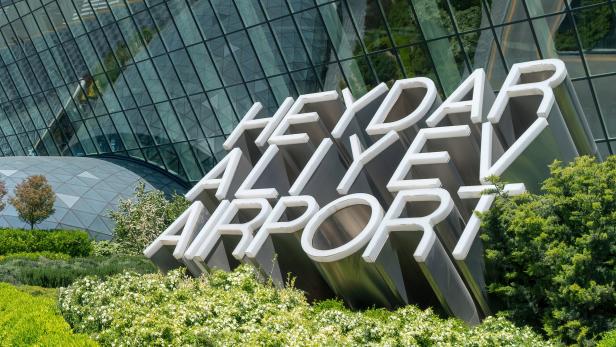 Das Schild „Heydar Aliyev Airport“ vor dem modernen Flughafengebäude.