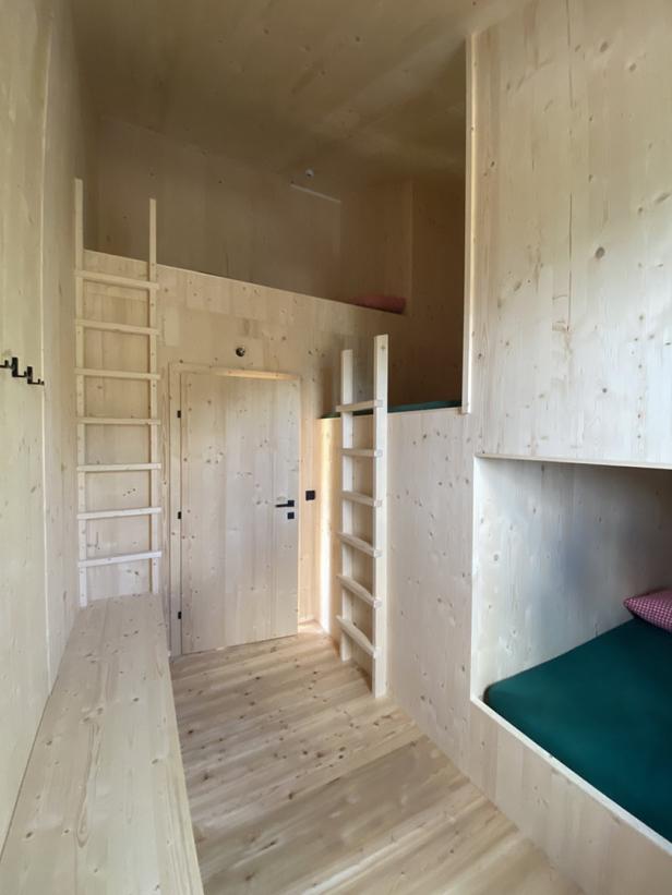 Ein Zimmer mit Holzvertäfelung und eingebauten Betten, erreichbar über Leitern.