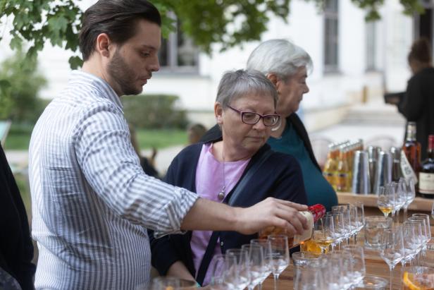 Ein Mann schenkt einer Frau ein Getränk in ein Glas ein.