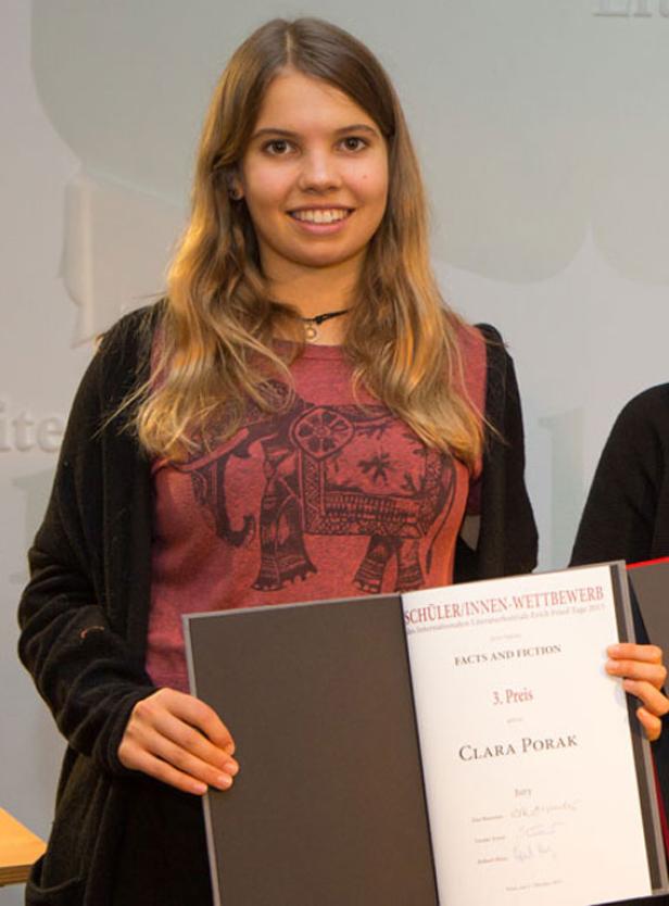 Clara Porak hält ihre Urkunde für den 3. Preis beim Schüler/innen-Wettbewerb „Facts and Fiction“.