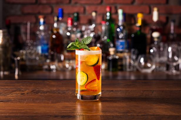 Ein Glas mit einem alkoholfreien Getränk, dekoriert mit Erdbeeren, Gurken und Minze.