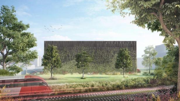 Ein Zug fährt an einem begrünten Gebäude mit der Aufschrift „Bücherdepot – Lager des Wissens“ vorbei.