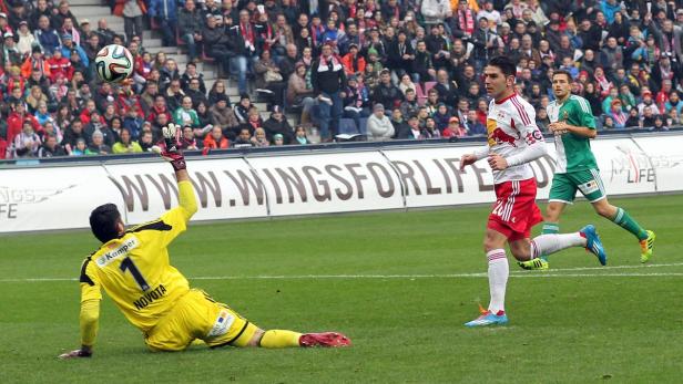 Ein Fußballtorwart versucht, einen Ball während eines Fußballspiels zu fangen.