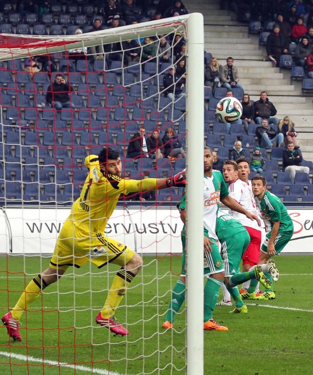 Ein Fußballtorwart versucht, einen Ball abzuwehren.