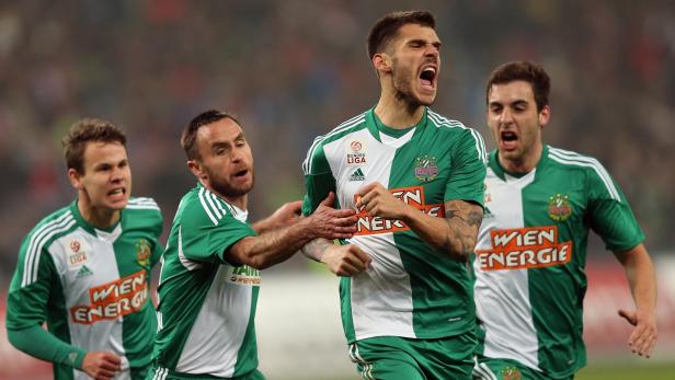 Mehrere Fußballspieler von Rapid Wien jubeln auf dem Spielfeld.