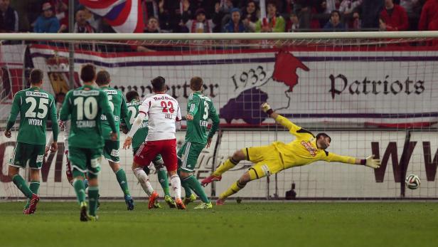 Ein Torwart hechtet, um einen Fußball während eines Fußballspiels zu halten.