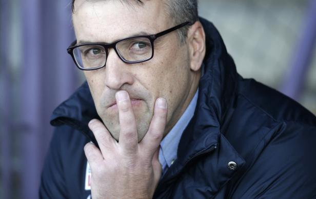 Ein Mann mit Brille und Winterjacke hält die Hand vor das Gesicht.