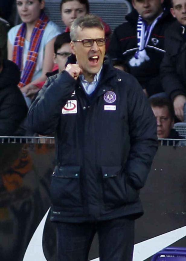 Ein aufgeregter Trainer mit Brille gestikuliert am Spielfeldrand.