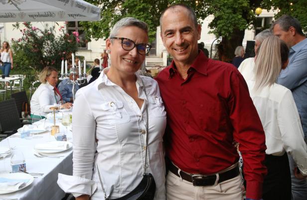 Ein lächelndes Paar posiert bei einer Veranstaltung im Freien für ein Foto.