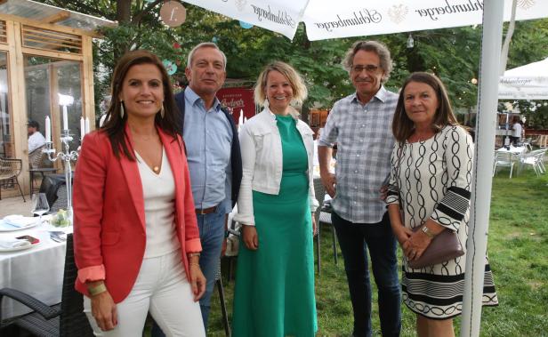 Fünf Personen posieren für ein Gruppenfoto im Freien.