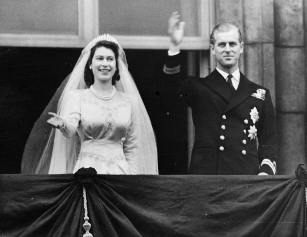 Königin Elizabeth II. und Prinz Philip winken an ihrem Hochzeitstag vom Balkon.