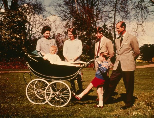 Die königliche Familie mit einem Kinderwagen im Garten.
