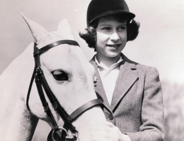Eine junge Elizabeth posiert mit einem Pferd.