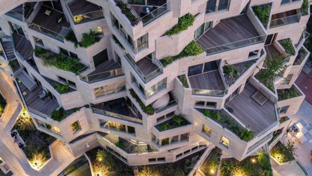 Luftaufnahme eines modernen Wohngebäudes mit begrünten Terrassen.