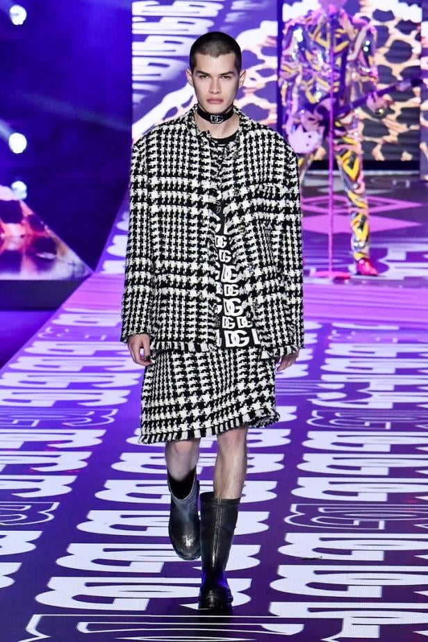 Ein Model in einem schwarz-weißen Hahnentritt-Outfit auf einem Laufsteg.