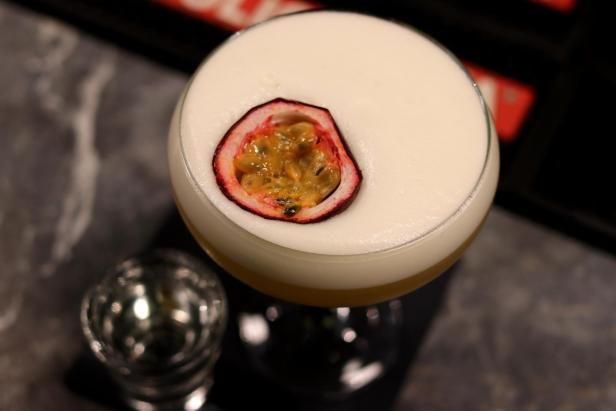 Ein Cocktail mit Passionsfruchtgarnitur auf einer cremigen Schaumkrone.