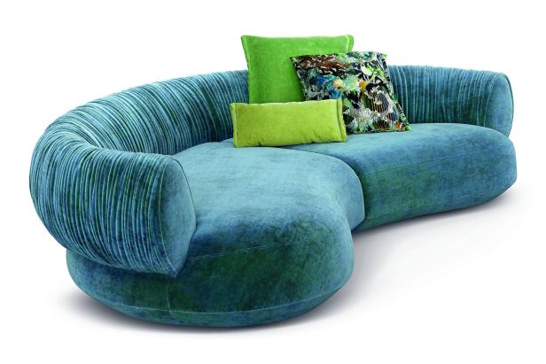 Ein blaugrünes Sofa mit grünen Kissen vor einem weißen Hintergrund.