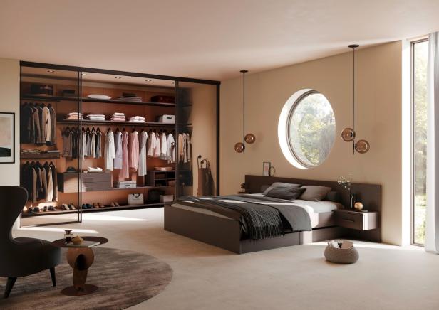 Ein modernes Schlafzimmer mit begehbarem Kleiderschrank und rundem Fenster.