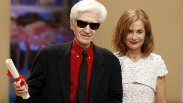 Agnès Varda und ein älterer Mann mit Sonnenbrille und einer Urkunde.