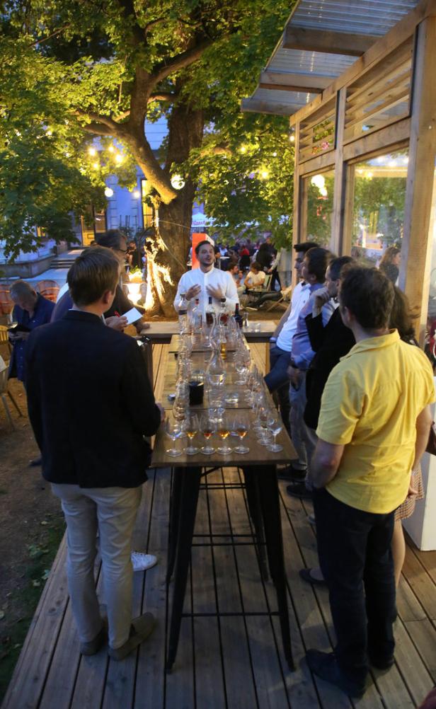 Eine Gruppe von Menschen nimmt an einer Weinprobe im Freien teil.