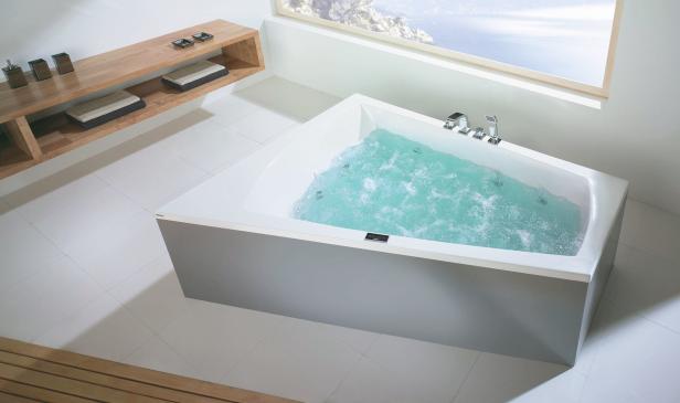 Ein Whirlpool ist mit blauem Wasser gefüllt und steht in einem modernen Badezimmer.