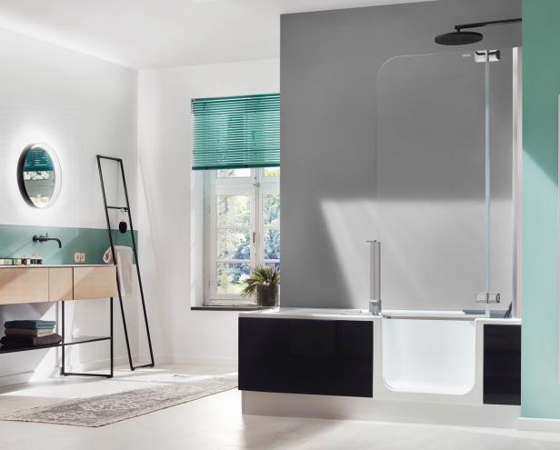 Ein modernes Badezimmer mit Badewanne, Waschtisch und grünen Akzenten.