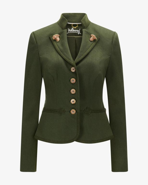 Eine grüne Trachtenjacke mit Hirsch-Anstecknadeln und Knöpfen in Holzoptik.