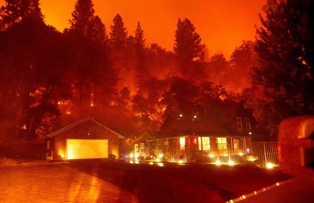 Ein Haus und eine Garage unter einem orangefarbenen Himmel, möglicherweise aufgrund eines Waldbrandes.