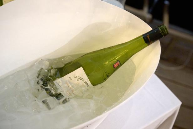 Eine Flasche „La Griffe Bernat“ Weißwein liegt in einem Eiskübel.