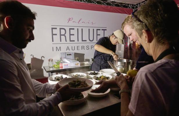 Köche bereiten im „Palais Freiluft im Auersperg“ Speisen mit Meeresfrüchten zu.