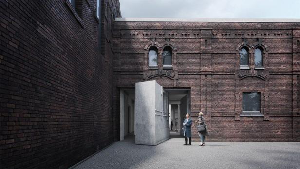 Zwei Personen stehen vor einem Gebäude mit einer Fassade aus roten Backsteinen.