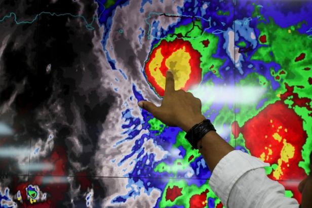 A member of the Emergency Operations Committee (COE) monitors the trajectory of Hurricane Fiona, in Santo Domingo