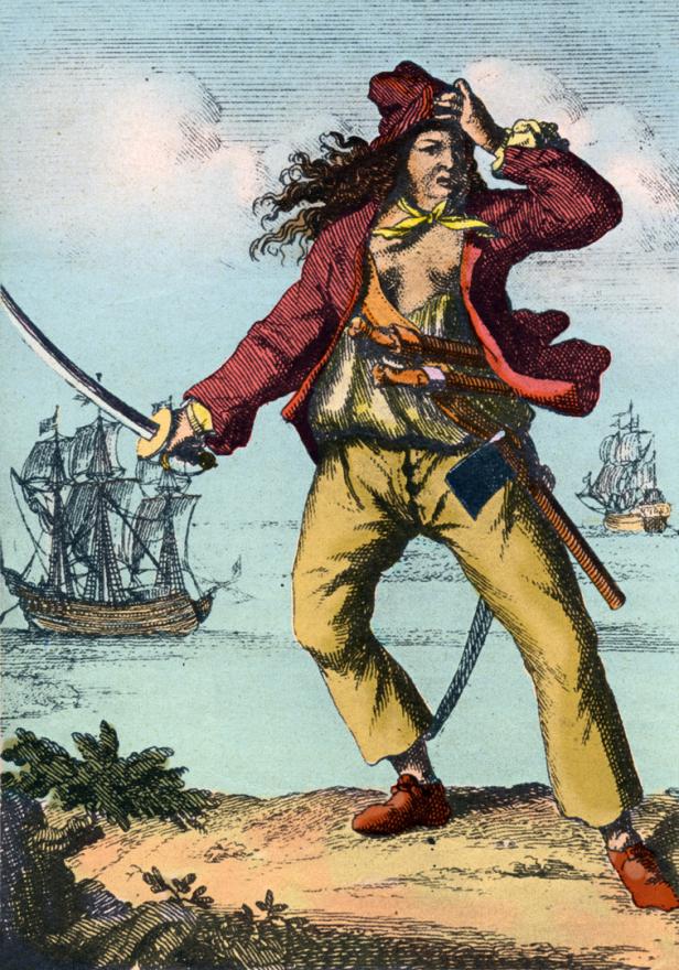 Ein Pirat mit Schwert und Pistolen steht an Land, im Hintergrund sind Segelschiffe zu sehen.