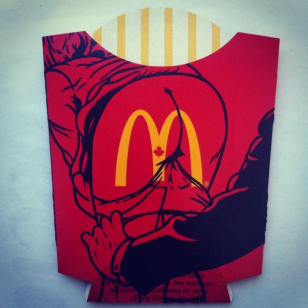 Eine McDonald's-Pommes-Frites-Verpackung mit einer Illustration, die ein aufgerissenes Hemd zeigt.
