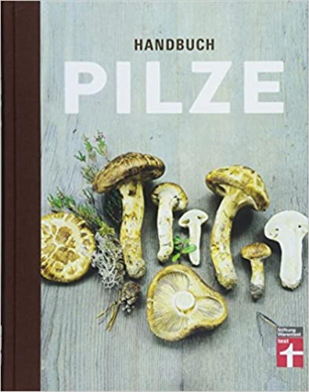 Das Cover eines „Handbuch Pilze“ Buches mit einer Auswahl von Pilzen darauf.