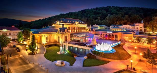 Das Casino Baden-Baden und seine beleuchteten Brunnen in der Abenddämmerung.