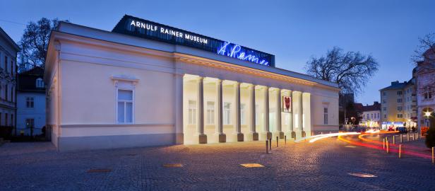 Das Arnulf Rainer Museum in Baden bei Nacht mit Lichtspuren vorbeifahrender Autos.