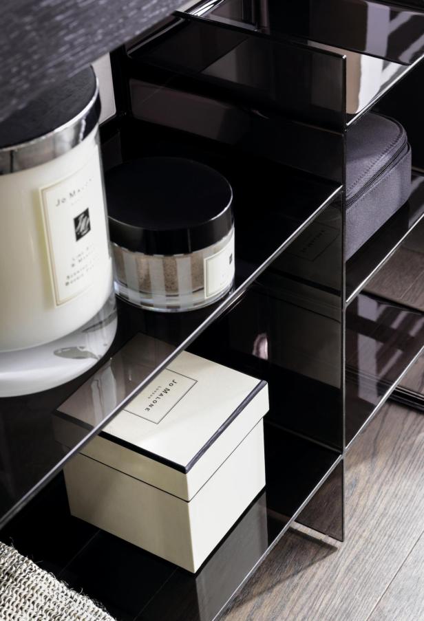Verschiedene Produkte von Jo Malone stehen in einem schwarzen Regal.