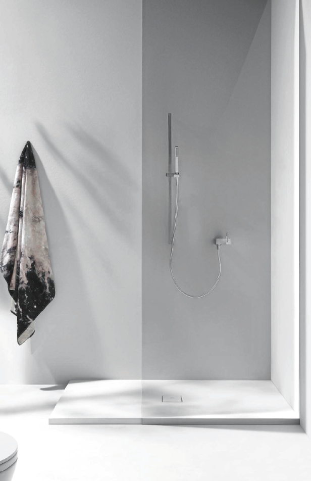 Eine moderne, ebenerdige Dusche mit Handtuch an der Wand.